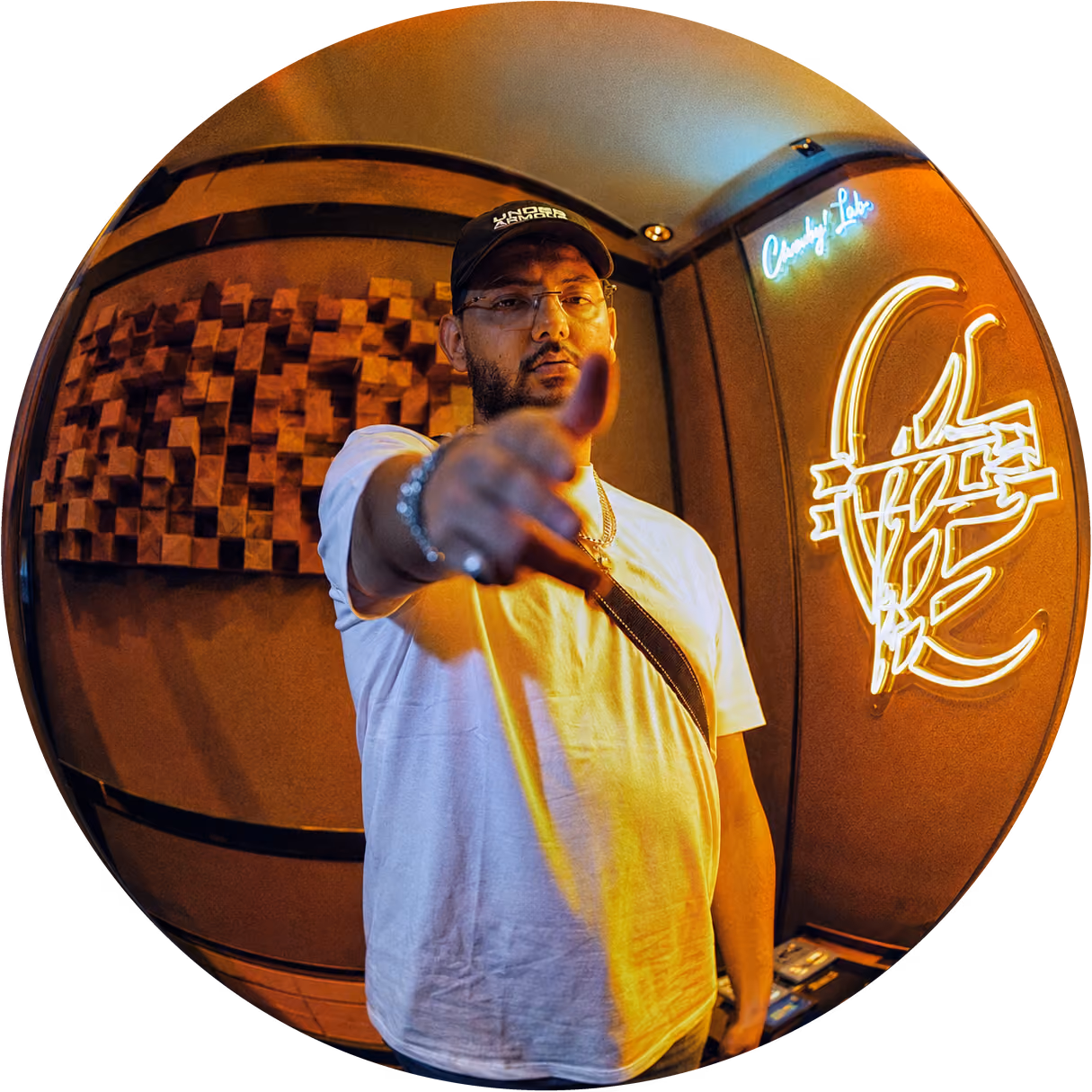 Skizo au Cherub's Lab, le bras tendu vers l'objectif, devant le logo du studio en néon